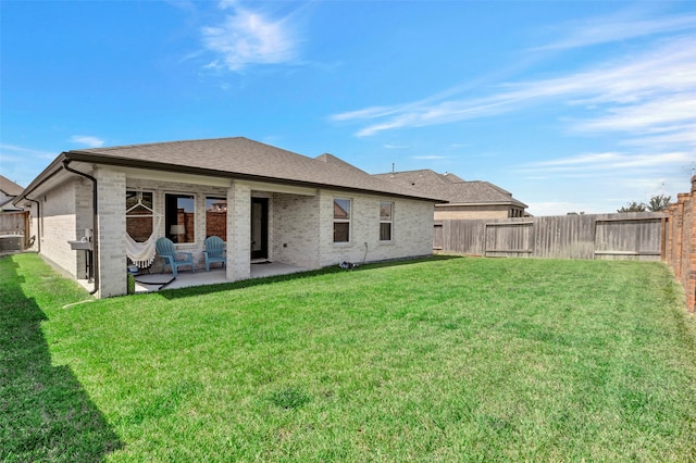 rear view of house featuring a yard and a patio area