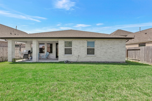 back of property featuring a patio and a yard