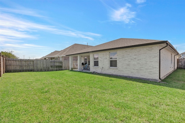 rear view of house featuring a lawn and a patio