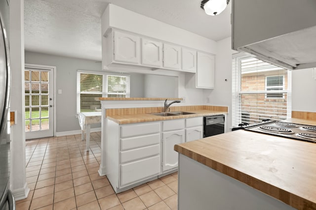 kitchen featuring light tile patterned flooring, sink, a textured ceiling, white cabinetry, and dishwasher