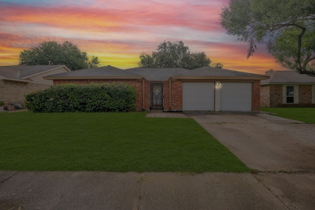 ranch-style home with a garage and a yard