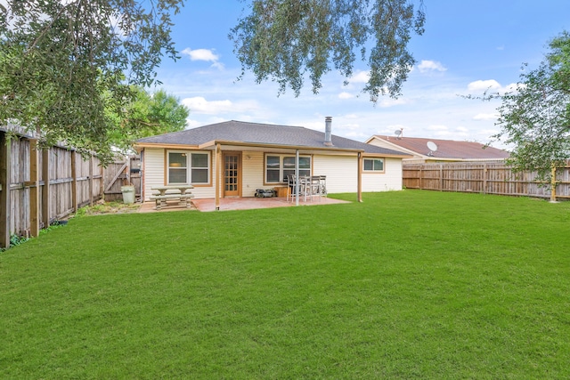 rear view of property featuring a patio and a yard