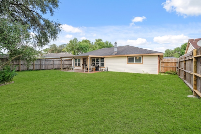 rear view of property with a yard and a patio area