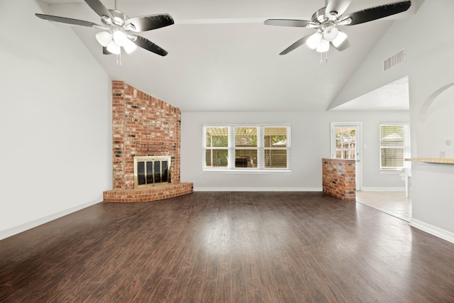 unfurnished living room featuring ceiling fan, a brick fireplace, dark wood-type flooring, and high vaulted ceiling