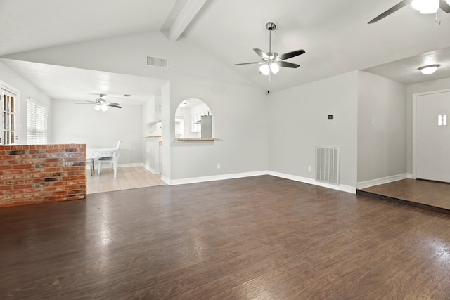 unfurnished living room with ceiling fan, vaulted ceiling with beams, and dark hardwood / wood-style floors