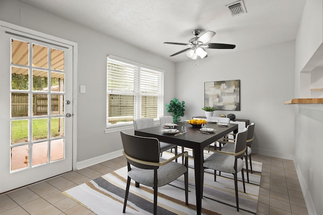 tiled dining space featuring ceiling fan and a textured ceiling