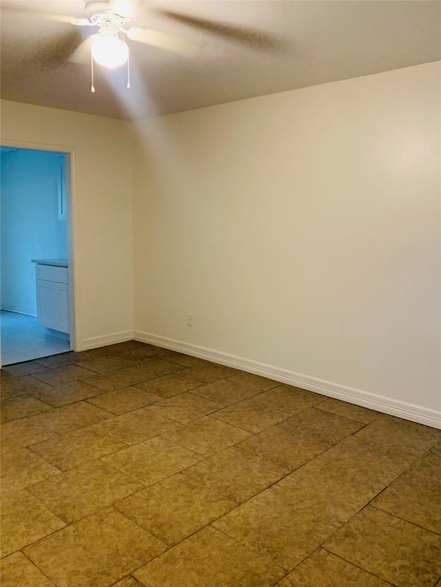 tiled spare room with ceiling fan