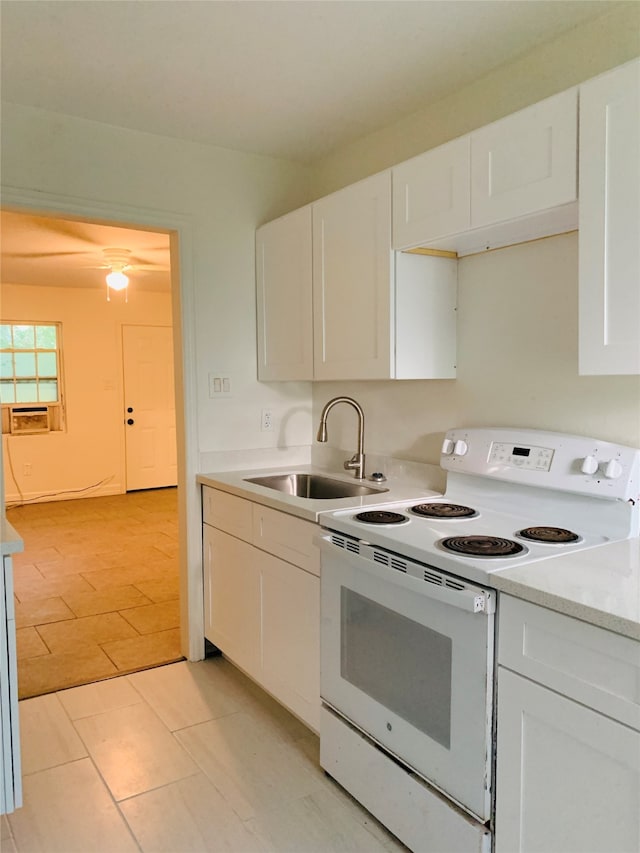 kitchen featuring light tile patterned flooring, sink, white electric stove, and white cabinetry