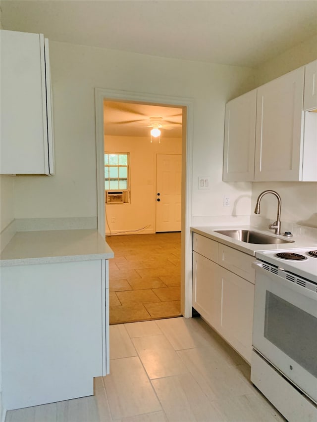 kitchen featuring light tile patterned floors, white range with electric cooktop, sink, and white cabinetry