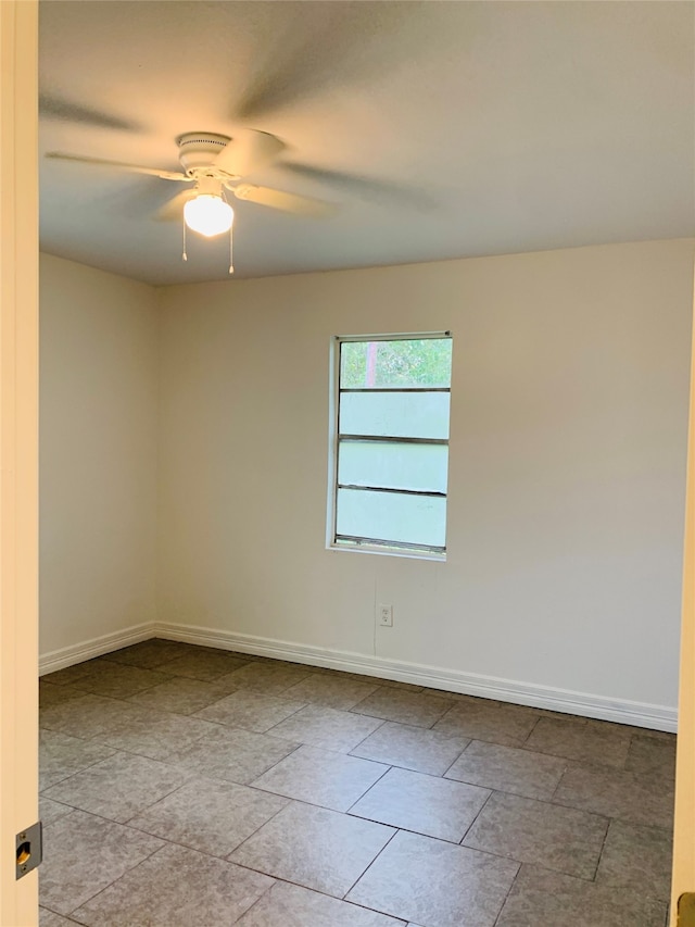 tiled spare room featuring ceiling fan