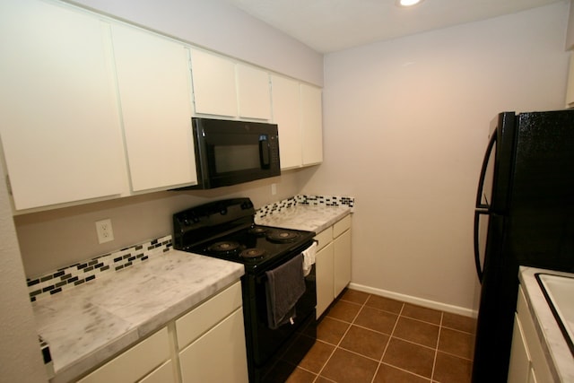 kitchen featuring black appliances, white cabinetry, and dark tile patterned floors