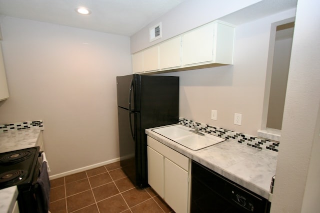 kitchen featuring tasteful backsplash, white cabinets, black appliances, dark tile patterned floors, and sink