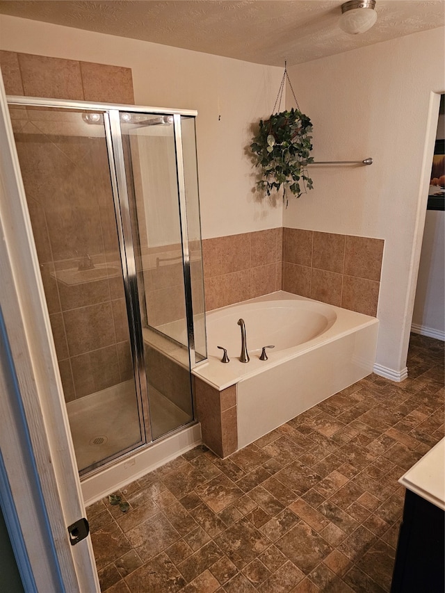 bathroom with independent shower and bath, vanity, and a textured ceiling