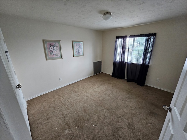 carpeted empty room featuring a textured ceiling