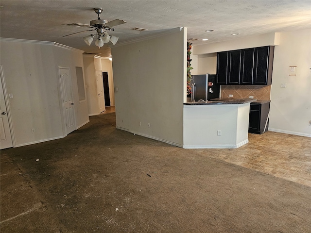 kitchen featuring a textured ceiling, stainless steel fridge, decorative backsplash, and ceiling fan