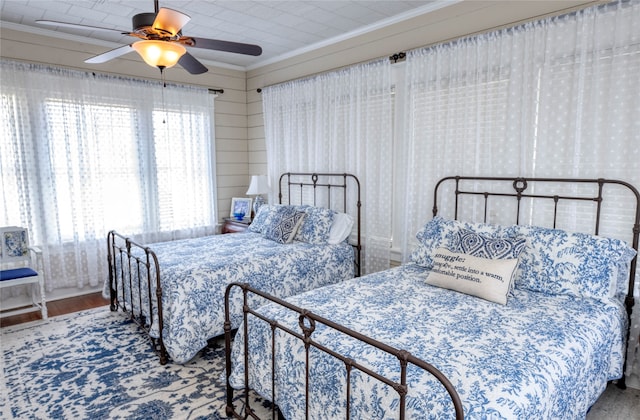 bedroom with crown molding, hardwood / wood-style floors, and ceiling fan