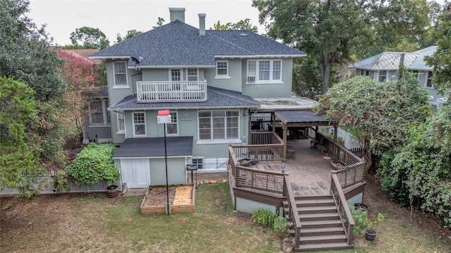 back of house with a shed, a lawn, and a wooden deck