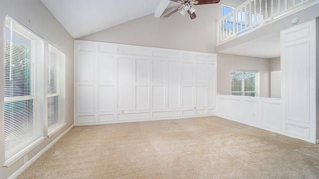 carpeted spare room with ceiling fan, beamed ceiling, and high vaulted ceiling