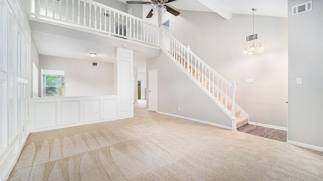 unfurnished living room featuring carpet floors, beamed ceiling, ceiling fan with notable chandelier, and high vaulted ceiling