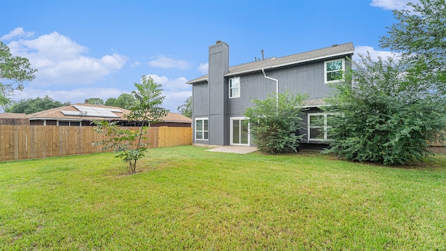 back of house with a lawn