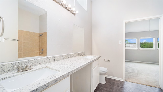 full bathroom with tiled shower / bath, vanity, toilet, and hardwood / wood-style flooring