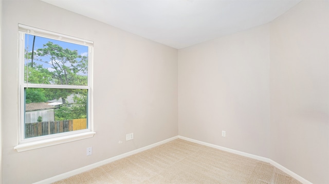 unfurnished room featuring light carpet