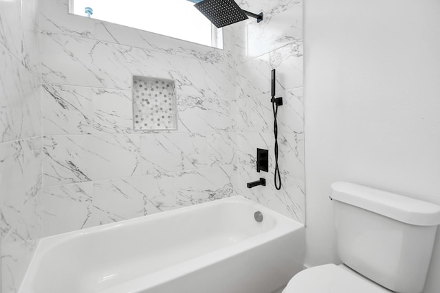 bathroom featuring tiled shower / bath combo and toilet