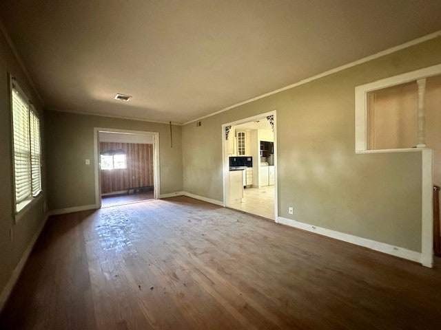 unfurnished living room with crown molding and hardwood / wood-style floors