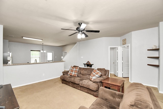 living room featuring a textured ceiling, carpet, sink, and ceiling fan