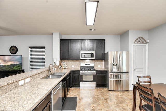 kitchen with decorative backsplash, stainless steel appliances, and sink