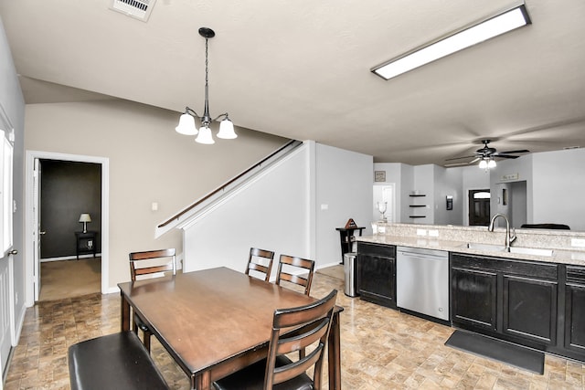 dining area with ceiling fan with notable chandelier and sink