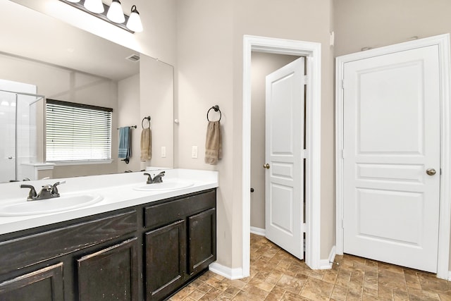 bathroom featuring a shower with shower door and vanity