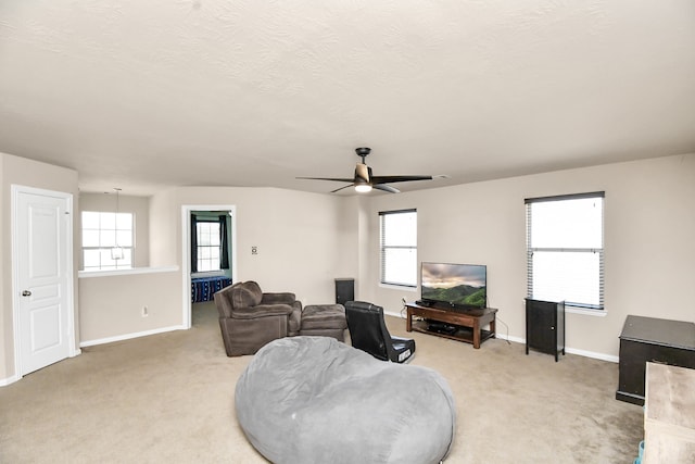 carpeted living room featuring ceiling fan, a textured ceiling, and a wealth of natural light