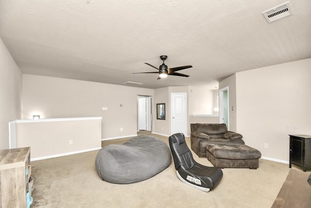 interior space with a textured ceiling, carpet flooring, and ceiling fan