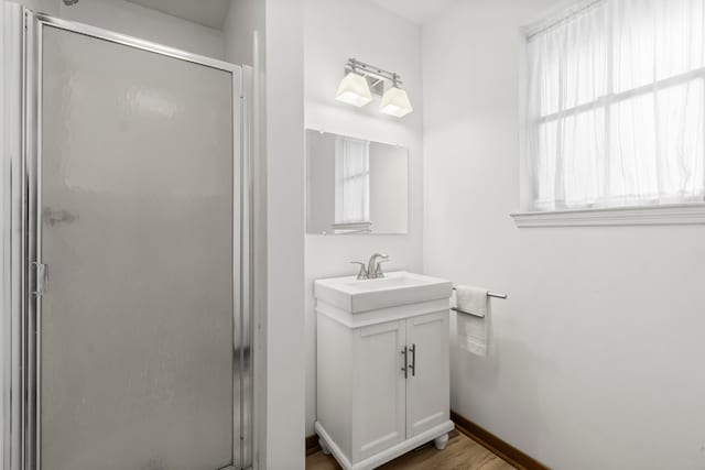 bathroom featuring vanity, hardwood / wood-style flooring, and a shower with shower door