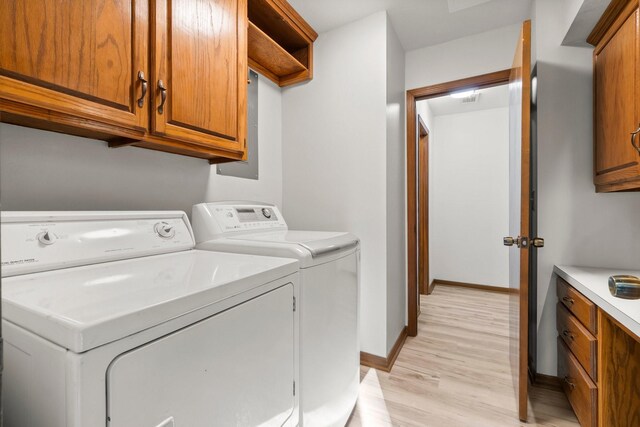6711 River Lodge Dr, Spring, TX 77379 - laundry room with baseboards, cabinet space, light wood finished floors, and washing machine and clothes dryer