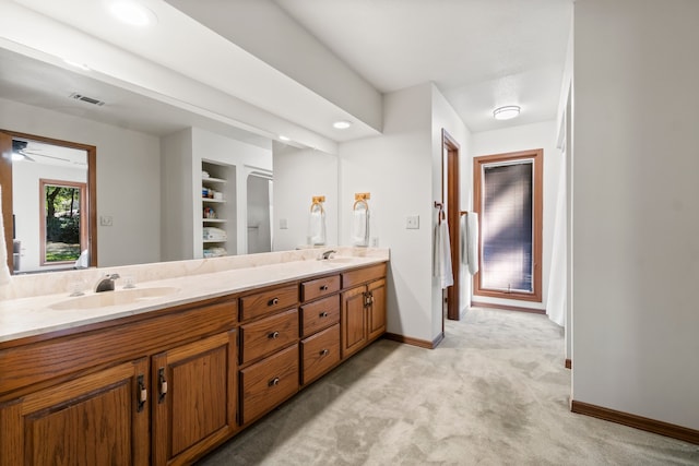 bathroom featuring vanity, ceiling fan, and built in shelves