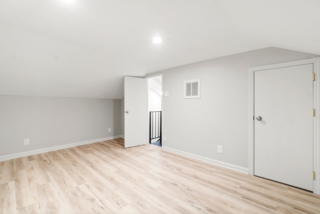 bonus room featuring lofted ceiling and light wood-type flooring