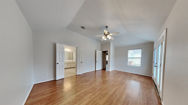 interior space featuring vaulted ceiling, ceiling fan, hardwood / wood-style flooring, and ensuite bath