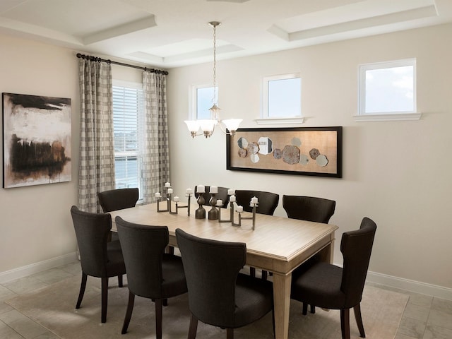 dining area featuring a tray ceiling and a notable chandelier