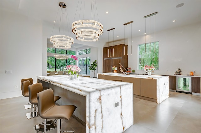 kitchen featuring decorative light fixtures, a center island, wine cooler, and a notable chandelier