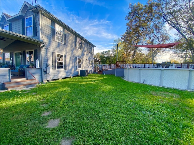 view of yard featuring a deck and central AC