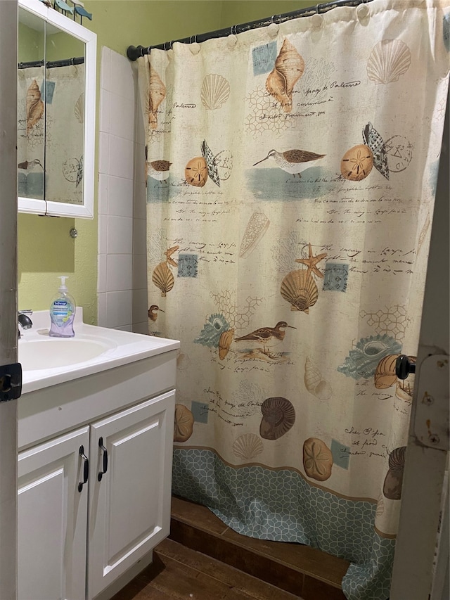 bathroom featuring wood-type flooring, vanity, and walk in shower