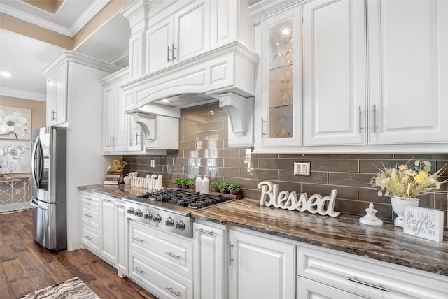 kitchen featuring dark stone counters, dark wood-type flooring, tasteful backsplash, white cabinets, and stainless steel appliances