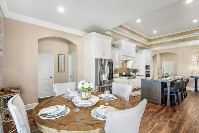 dining room with ornamental molding, dark hardwood / wood-style flooring, and sink