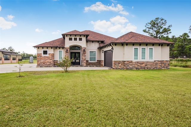 mediterranean / spanish house with a front lawn and a garage