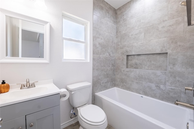 full bathroom featuring vanity, tiled shower / bath combo, and toilet