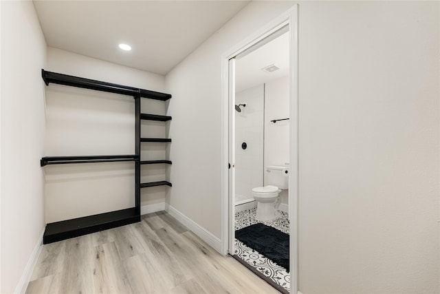 full bathroom with visible vents, toilet, a shower stall, wood finished floors, and baseboards