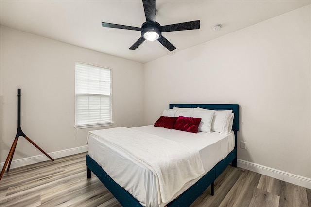 bedroom featuring ceiling fan, baseboards, and wood finished floors