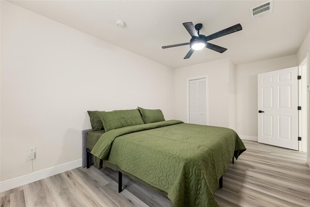 bedroom featuring ceiling fan, a closet, and light wood-type flooring